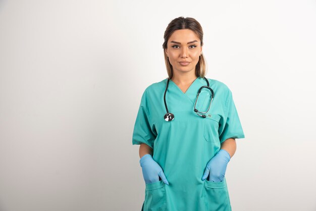 Joven enfermera posando vestida con bata médica.