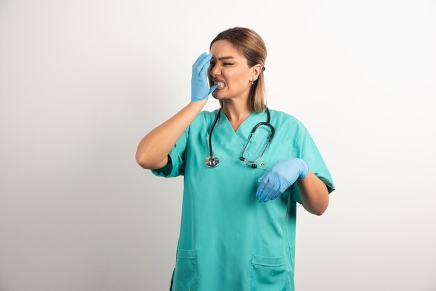 Joven enfermera posando vestida con bata médica.