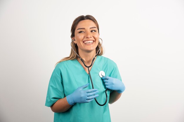 Joven enfermera sonriente posando con estetoscopio.