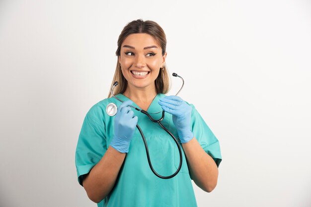 Joven enfermera sonriente posando con estetoscopio.