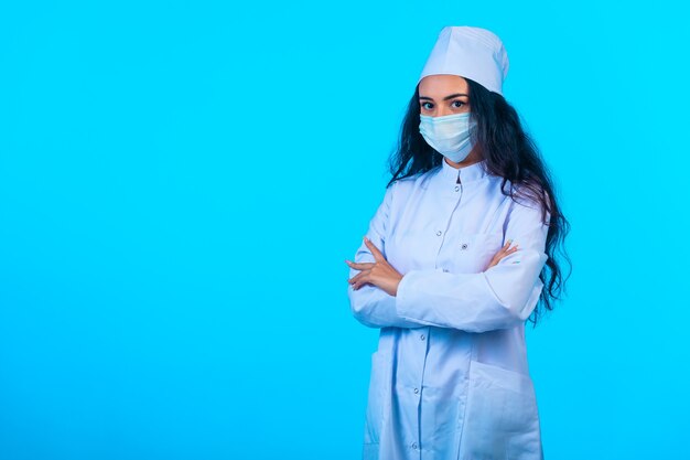 Joven enfermera en uniforme aislado sosteniendo las manos cerradas y parece seguro de sí mismo.