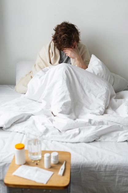 Foto gratuita joven enfermo en su cama