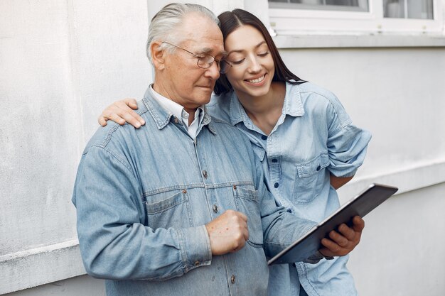 Joven enseñando a su abuelo a usar una tableta