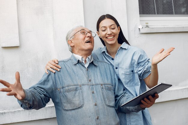 Joven enseñando a su abuelo a usar una tableta