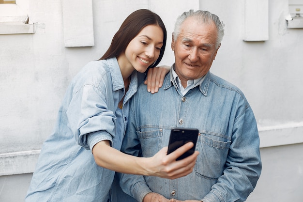 Foto gratuita joven enseñando a su abuelo a usar un teléfono