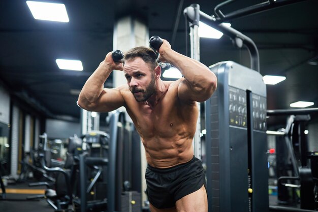 Foto gratuita joven en entrenamiento de gimnasia tirando de pesas