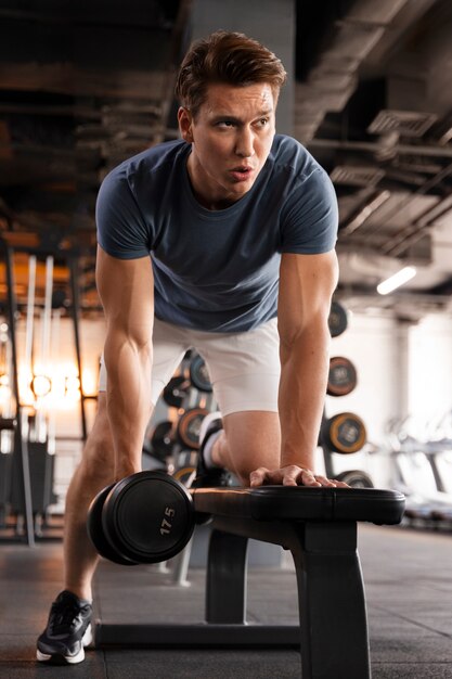 Joven entrenando en el gimnasio para culturismo