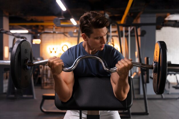 Joven entrenando en el gimnasio para culturismo