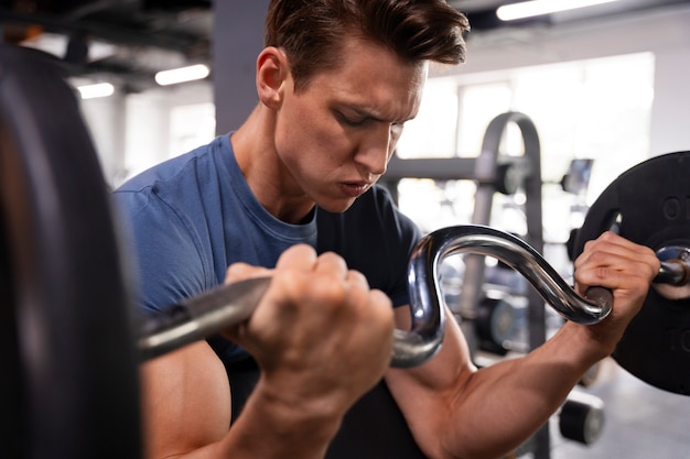 Foto gratuita joven entrenando en el gimnasio para culturismo