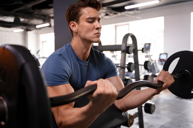 Joven entrenando en el gimnasio para culturismo