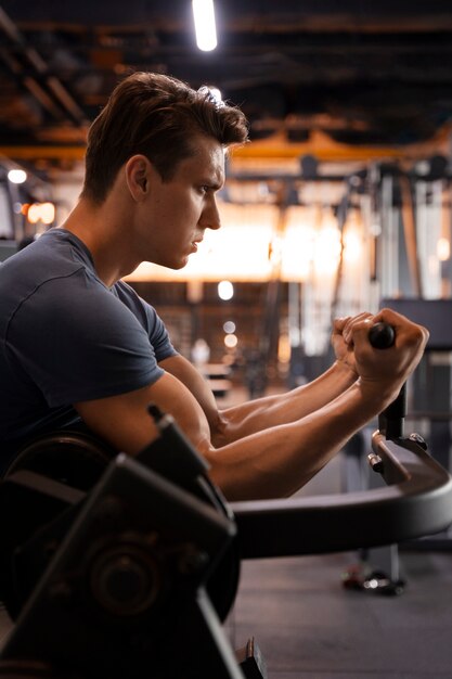 Joven entrenando en el gimnasio para culturismo