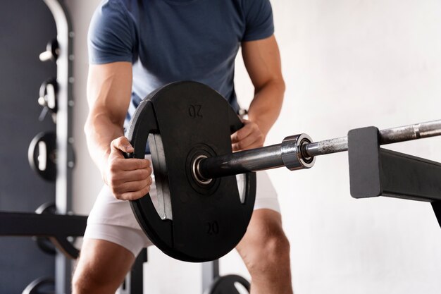 Joven entrenando en el gimnasio para culturismo