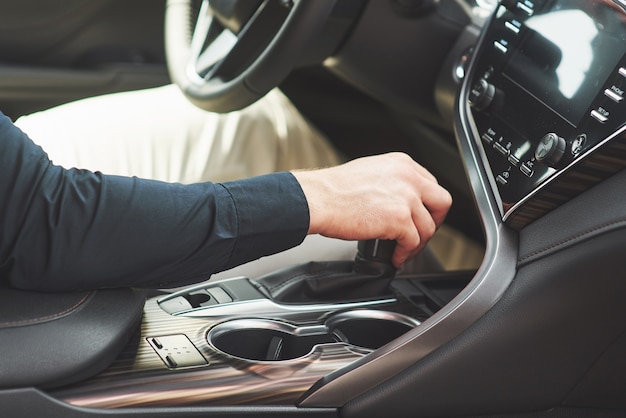 El joven es un hombre al volante de un automóvil arbóreo.