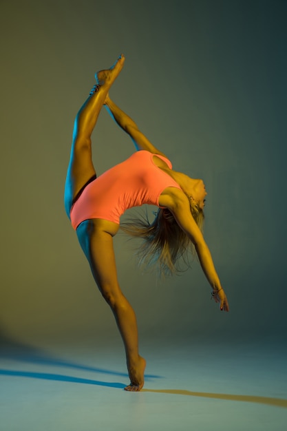 Joven esbelta gimnasia haciendo acrobacias