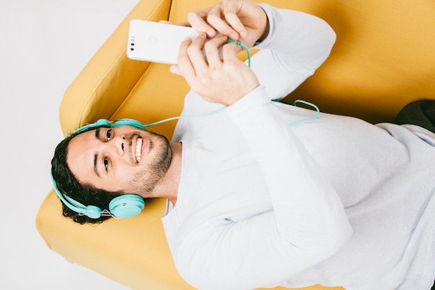 Joven escribiendo un mensaje y escuchando música