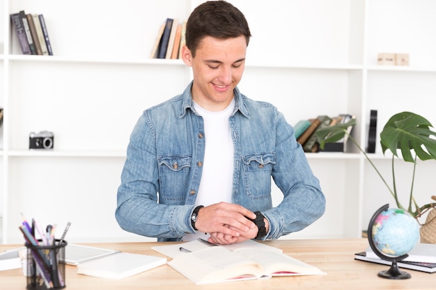 Joven, en el escritorio, mirar el reloj