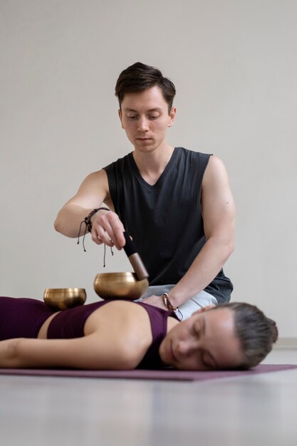 Joven espiritual y mujer practicando yoga en el interior