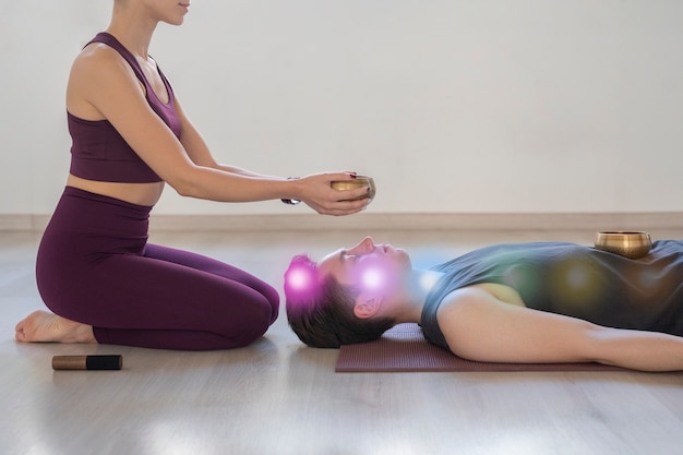 Joven espiritual y mujer practicando yoga en el interior