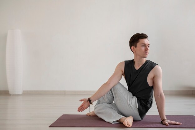 Joven espiritual practicando yoga en el interior