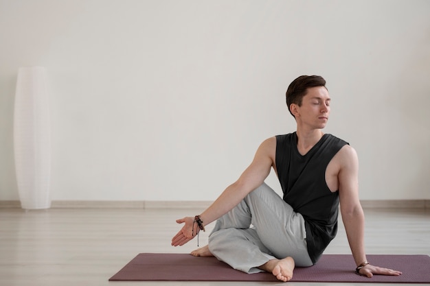 Joven espiritual practicando yoga en el interior