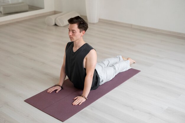 Joven espiritual practicando yoga en el interior