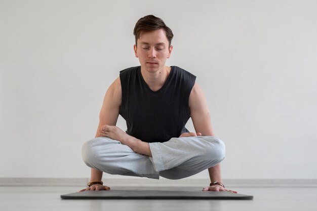 Joven espiritual practicando yoga en el interior