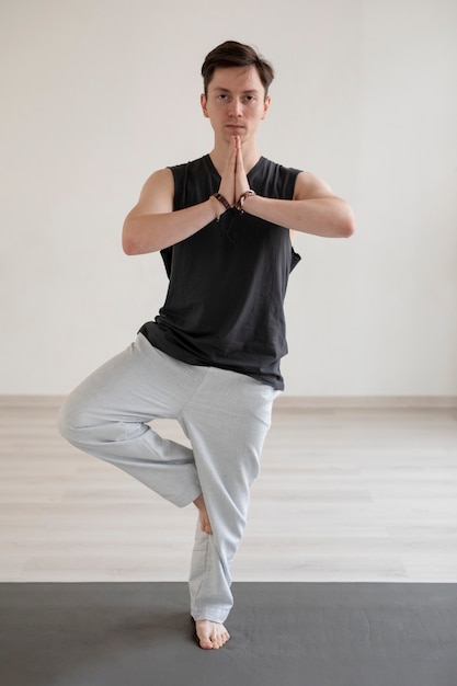 Joven espiritual practicando yoga en ropa deportiva