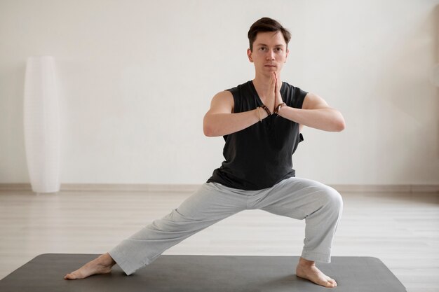 Joven espiritual practicando yoga en ropa deportiva