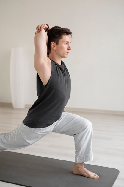 Joven espiritual practicando yoga en ropa deportiva