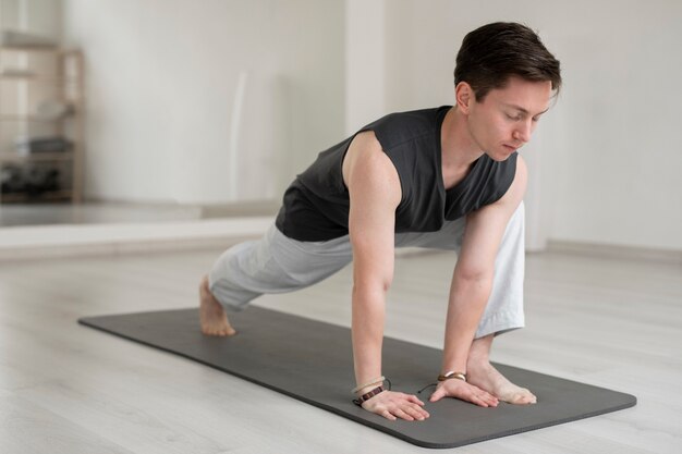 Joven espiritual practicando yoga en ropa deportiva