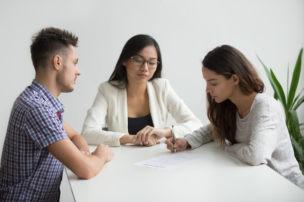 Foto gratuita joven esposa firmar papeles de divorcio en la oficina de abogado