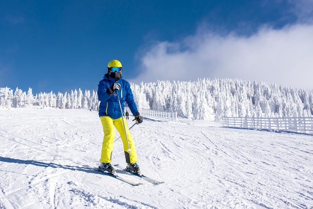 Joven esquiador en movimiento con un hermoso paisaje invernal