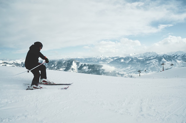 Un joven esquiando en las montañas cubiertas de nieve.
