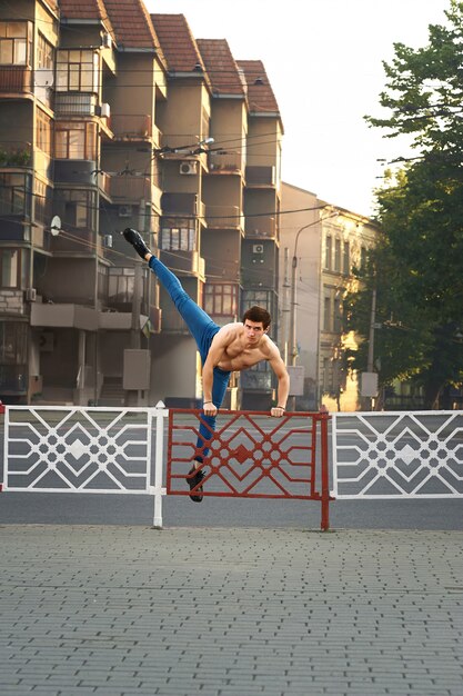 Joven está bailando en las calles de la ciudad de mañana.