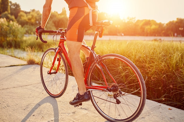 Joven está ciclismo bicicleta de carretera en la noche