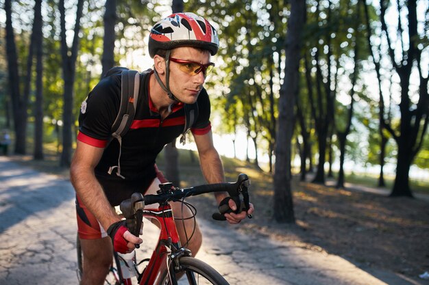 Joven está ciclismo bicicleta de carretera en la noche