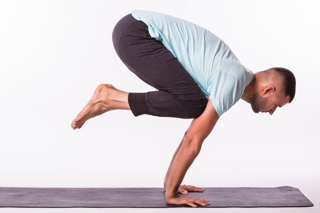 Joven está haciendo yoga aislado sobre fondo blanco.