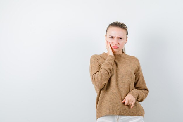 La joven está mostrando su emoción disgustada en el fondo blanco