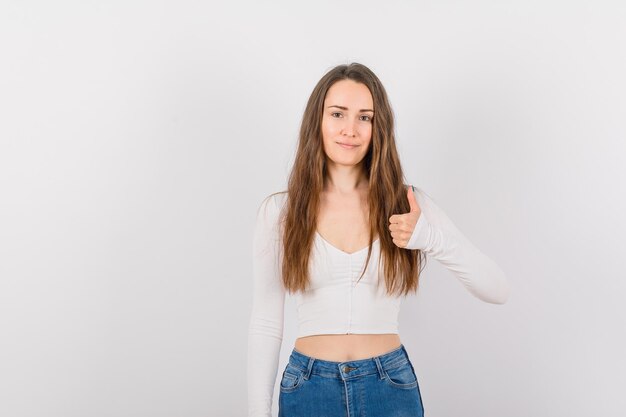 La joven está sonriendo mostrando un gesto perfecto en el fondo blanco