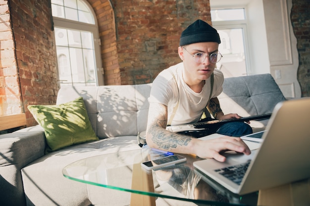 Joven estudiando en casa durante cursos en línea o información gratuita por sí mismo