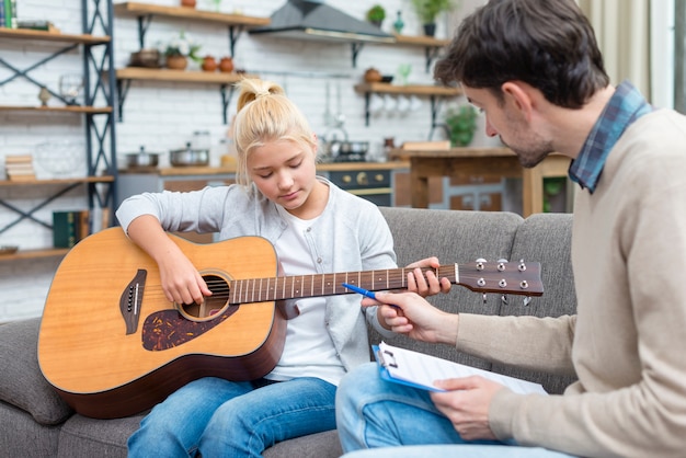 Joven estudiante aprendiendo a sostener la guitarra