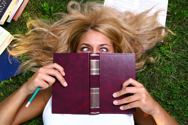 Joven estudiante atractivo leyendo el libro