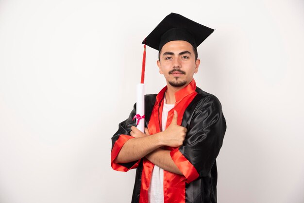 Joven estudiante con diploma posando en blanco.