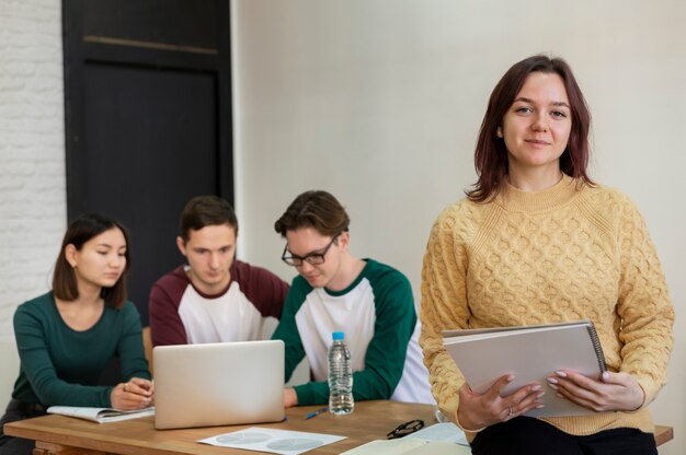 Joven estudiante durante el estudio en grupo posando en el escritorio