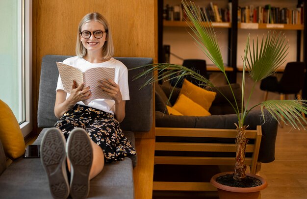 Joven estudiante leyendo un libro en la biblioteca