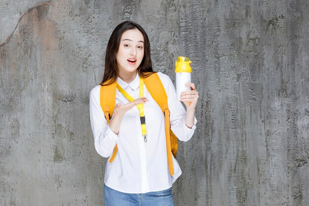 Joven estudiante en mochila con botella de agua. foto de alta calidad