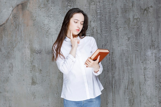 Joven estudiante o profesor con camisa blanca sosteniendo un libro. foto de alta calidad