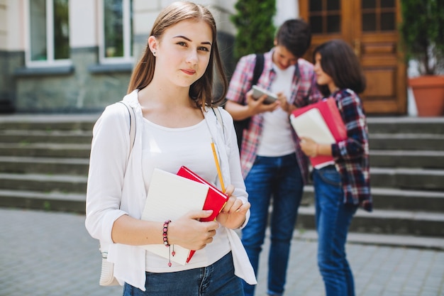 Joven estudiante posando cerca de la universidad