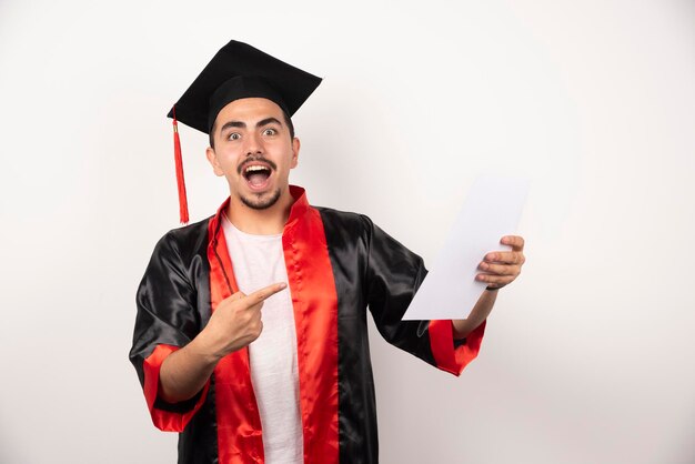 Joven estudiante de posgrado en vestido señalando papel en blanco.