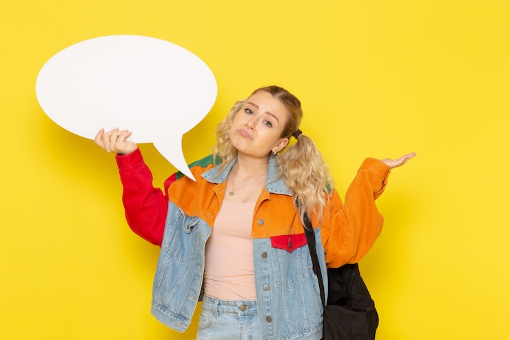 Foto gratuito joven estudiante en ropa moderna con un cartel blanco sobre amarillo
